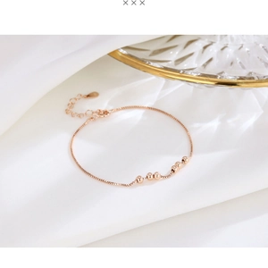Detail of rose gold box chain bracelet with spherical beads and lobster clasp closure