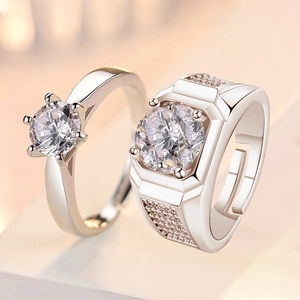 Macro shot of silver couple rings with round gemstones and adjustable open bands
