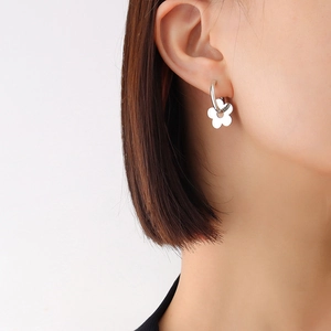 Minimalist silver flower hoop earrings in titanium steel for women on white background
