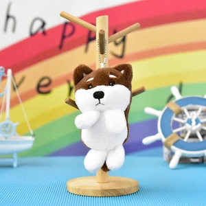 Λεπτομέρεια ενός χαριτωμένου Shiba Inu λούτρινου μπρελόκ σε ξύλινη βάση