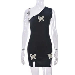 Detail of rhinestone bow accents and side slit on this black one-shoulder dress