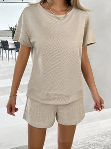 Detail of beige summer knit set featuring geometric square embossing and textured fabric