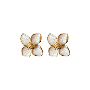 Elegante weiße Emaille-Blumenohrstecker mit Goldbeschichtung auf weißem Hintergrund