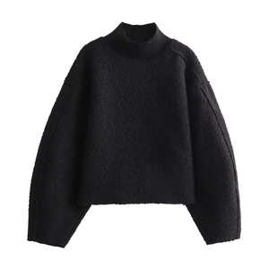 Close-up of black loose knit sweater featuring soft textured fleece and ribbed cuffs detail