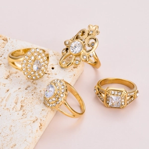 Set of four gold-plated stainless steel rings with zirconia and heart flower motifs