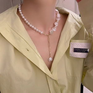 Chic pearl necklace featuring asymmetric baroque pearls and a long gold heart pendant