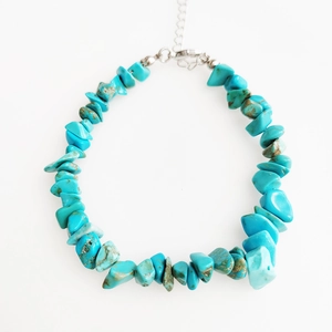 Detailed close-up of irregular turquoise gemstone beads and silver extension chain