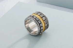 Detail of wide mixed-metal band ring with hammered texture and cubic zirconia inlay