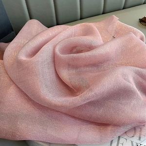 Close-up of pink silk scarf detail showing soft texture and subtle golden sheen