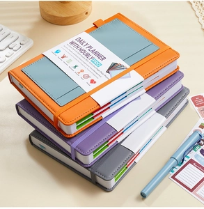 Close-up of undated daily planner with elastic strap, side tabs and hourly schedule layout