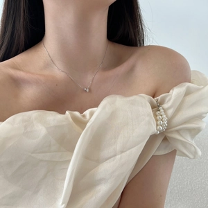 Detail of elegant S925 sterling silver heart necklace with white pearl collar accents