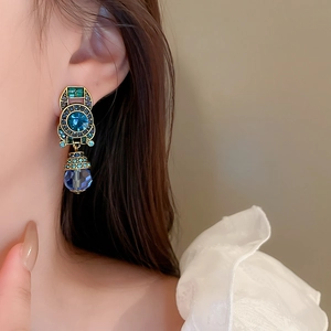 Macro view of vintage French clip earrings featuring blue crystals and teardrop pendants