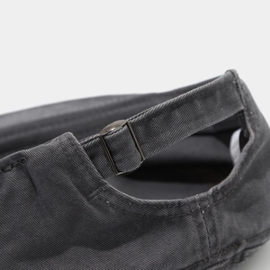 Detail of adjustable metal slider buckle and cotton twill texture on dark grey cap