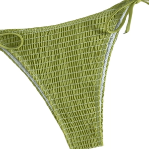 Grass green halter bikini with smocked texture and adjustable side ties on white background