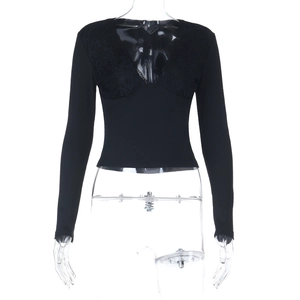 Dettaglio dello scollo a V con pizzo e trama a costine sulla maglia nera a maniche lunghe
