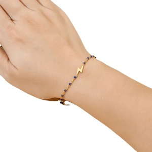 Bohemian gold lightning charm bracelet with blue seed beads on female wrist