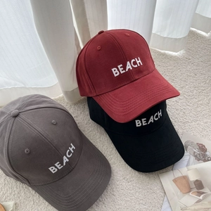 Close-up of BEACH letter embroidery on solid cotton canvas baseball caps in multiple colors