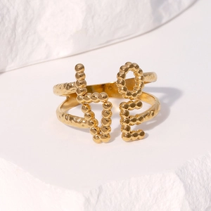 Gold plated LOVE letter open ring with beaded texture on white stone background