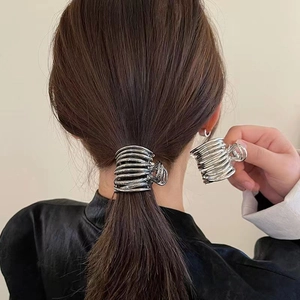 Detail of silver metallic multi-layer coil hair claw clip for high ponytail styling