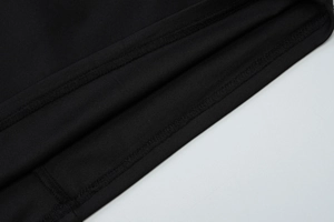 Macro shot of double-needle stitching and texture on a black fitted sleeveless dress