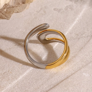 Detailed close-up of two-tone gold and silver rotating stainless steel open ring