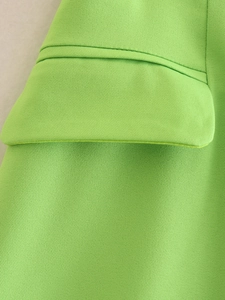 Close-up of lime green twill fabric texture and stitching detail on jacket pocket