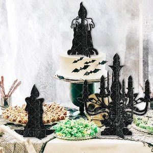 Detail of black glitter Halloween candle holder cake toppers on a themed party table