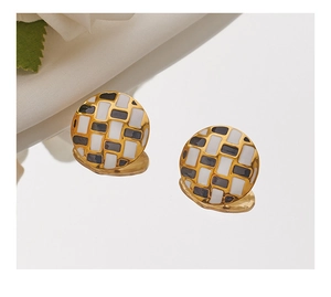 Close-up of geometric square checkerboard stud earrings with gold finish and enamel detail