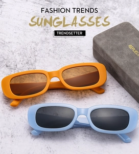 Detail of square vintage sunglasses in bright orange and light blue with suede case