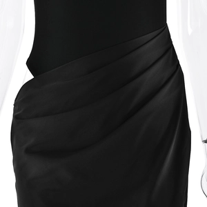 Detail view of the gathered waist design and ruched fabric on a black maxi dress