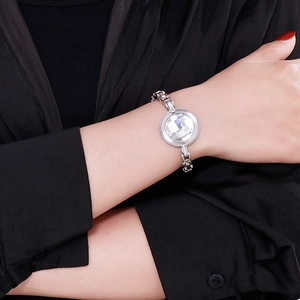 Detailed shot of a silver chain bracelet with a large clear crystal on a female wrist