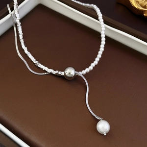 Detailed close-up of French style pearl necklace with silver irregular beads and Y-shaped pendant