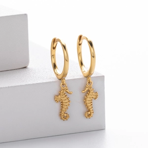 Minimalist gold seahorse drop earrings crafted in S925 sterling silver on white cubes