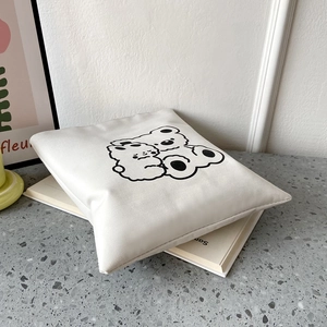 Detail shot of the cream canvas tote bag featuring a cute black double bear graphic print