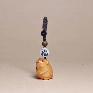 Detailed view of hand-carved wooden hamster pendant with lucky bead and woven rope