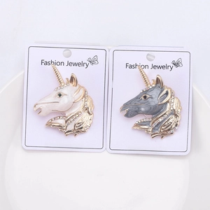Detail of colorful enamel unicorn head brooches with gold plating and sparkling rhinestones