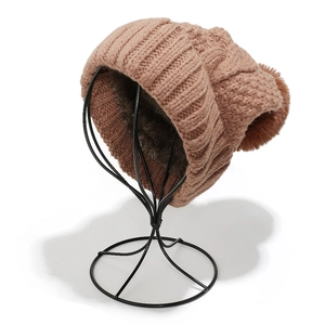 Detail of chunky cable knit winter hat with thick faux fur lining and large pompom