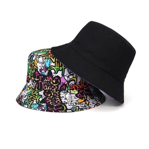Detail of reversible bucket hat showing minimalist black side and vibrant graffiti print