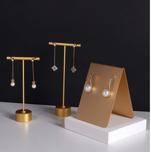 Detailed view of matte gold metal jewelry display stands for earrings and jewelry sets