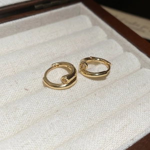 Gros plan de boucles d'oreilles créoles plaquées or 18 carats dans un écrin en bois chic