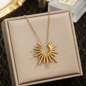 Modern gold stainless steel sunburst pendant necklace displayed on a luxury jewelry box