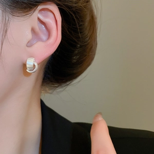 Detail of silver double-layered C-shape earrings with matte and polished texture on model