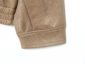 Gros plan détaillé des poignets élastiques d'une veste en daim kaki avec coutures