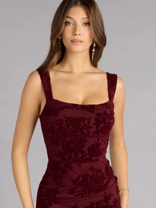 Detail of burgundy velvet dress featuring elegant square neck and floral embossed texture