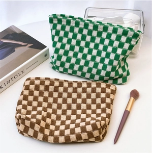 Detailed knit texture of green and brown checkered cosmetic bags with zipper closure
