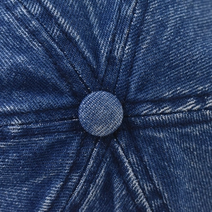 Macro detail of dark blue washed denim fabric on the 1983 embroidered baseball cap