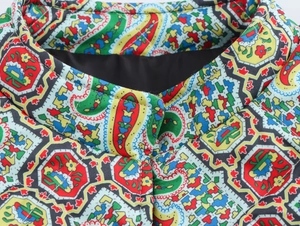 Detail of stand-up collar showing intricate paisley prints and quilted texture of the jacket