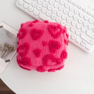 Détail de la trousse de maquillage en peluche à motif cœur avec fermeture éclair