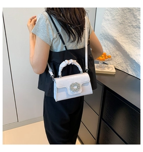 Détail du sac à bandoulière blanc à motif crocodile avec boucle florale en cristal