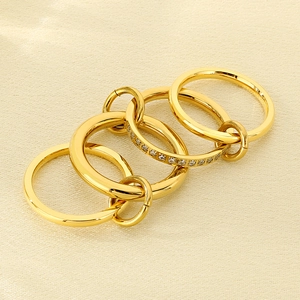 Detail of five linked gold stainless steel rings with micro-pave diamond accents